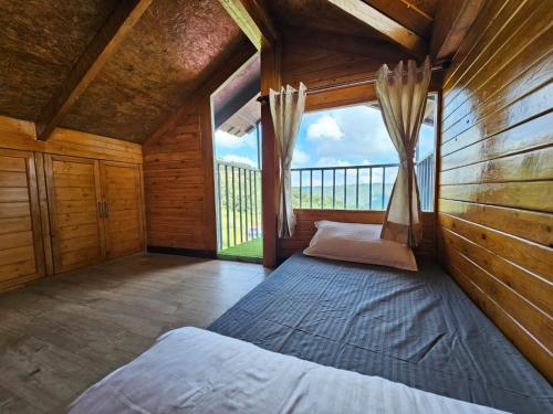 a bedroom with a bed in a room with a window at Himalayan Havenwood in Mukteshwar