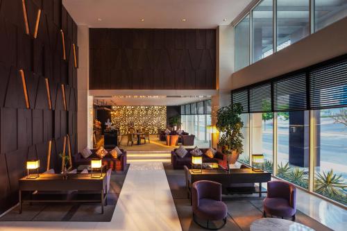 a lobby with couches and tables in a building at Flora Creek Deluxe Hotel Apartments in Dubai