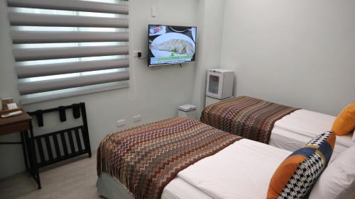 a room with two beds and a tv on the wall at 日日旅樹 Green Stay in Hualien City