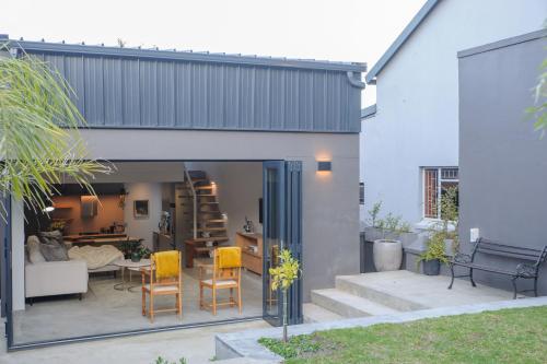 a house with a patio with yellow chairs at Oranje Meul in Paarl