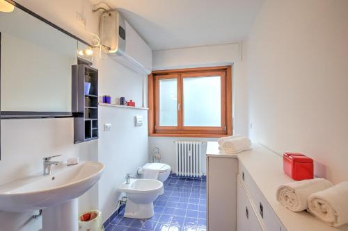 baño con lavabo y aseo y ventana en Terrazza Dei Principi Few Steps From Ski - Happy Rentals en Sestriere