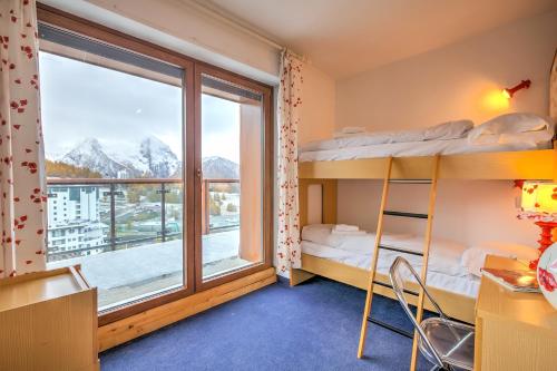 a dorm room with bunk beds and a large window at Terrazza Dei Principi Few Steps From Ski - Happy Rentals in Sestriere