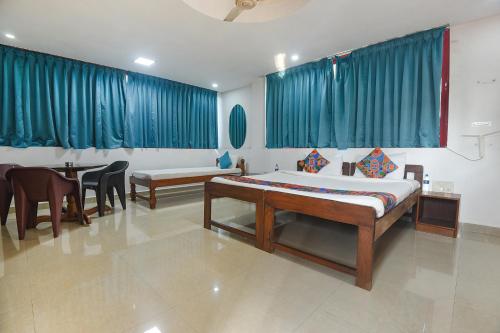 a bedroom with a bed and a table and chairs at FabExpress Stargaze Beach in Anjuna