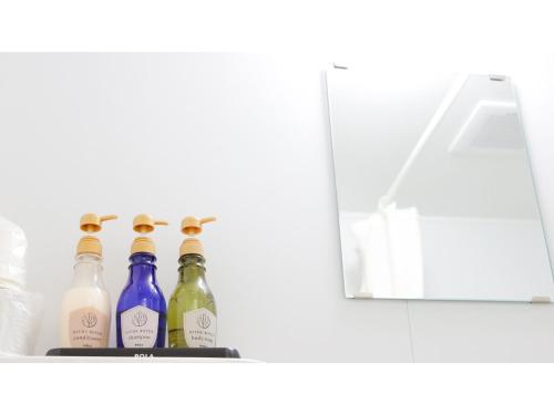 una fila di bottiglie di vino in un frigorifero di HOTEL Nishikawaguchi Weekly - Vacation STAY 43454v a Saitama