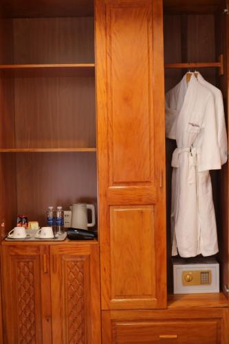 a closet with a white shirt and a robe at Phú Long Tam Kỳ Hotel & Restaurant in Tam Ky