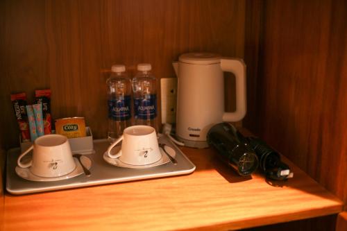 a wooden counter with two cups and a coffee maker at Phú Long Tam Kỳ Hotel & Restaurant in Tam Ky