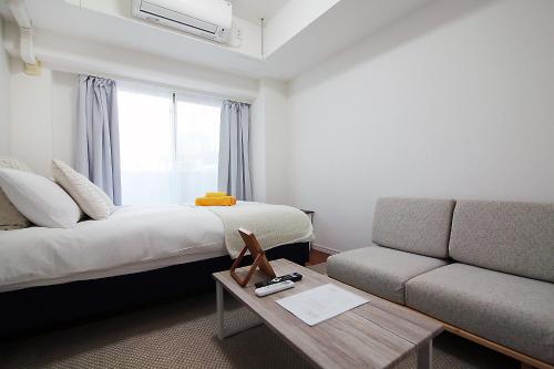 een hotelkamer met een bed en een bank bij SQ) SHIBUYA HOUSE in Tokyo