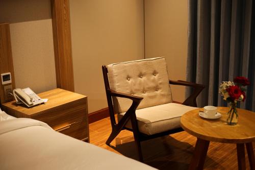 a bedroom with a chair and a table and a phone at Phú Long Tam Kỳ Hotel & Restaurant in Tam Ky