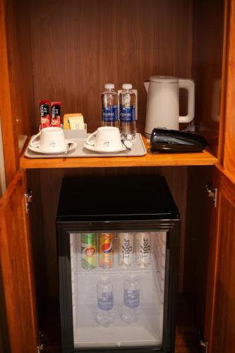 a small refrigerator with bottles of water and drinks at Phú Long Tam Kỳ Hotel & Restaurant in Tam Ky
