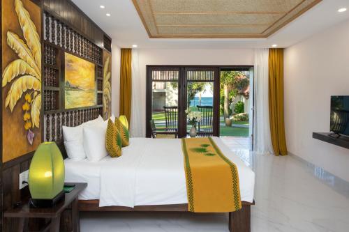a bedroom with a bed and a balcony at Palm Garden Beach Resort & Spa in Hoi An