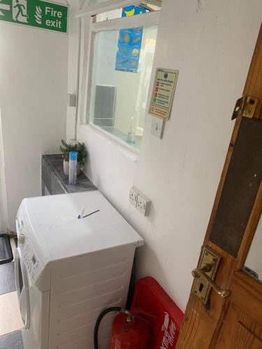 ein kleines Zimmer mit einer Waschmaschine und einem Fenster in der Unterkunft Gordon Road in Gillingham