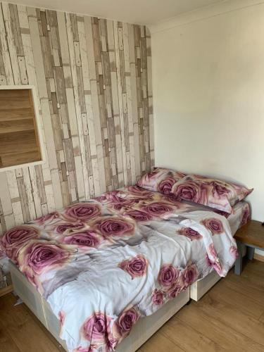 a bed with pink roses on it in a room at Gordon Road in Gillingham