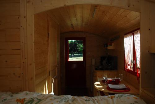 Zimmer mit einem Bett, einem Tisch und einem Fenster in der Unterkunft Gypsy Nature B&B in Jumelles
