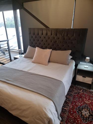 a bedroom with a large bed with a large headboard at CM Loft Maboneng in Johannesburg