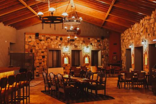 a dining room with tables and chairs and a stone wall at Alaçatı Route 35 Glamping Konaklama&Restaurant in Germiyan