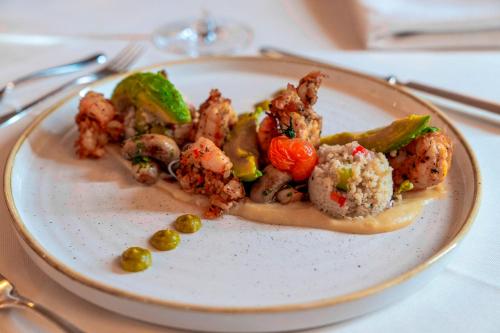 a plate of food with meat and vegetables on a table at Waldhof Fuschlsee Resort in Fuschl am See