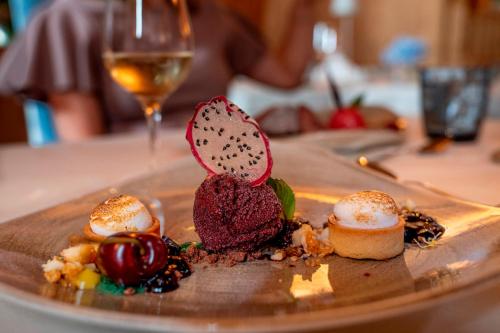 a plate of food on a table with a glass of wine at Waldhof Fuschlsee Resort in Fuschl am See