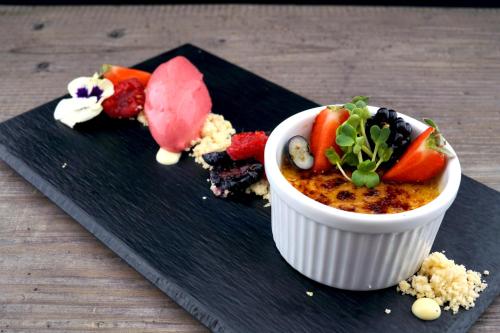 a black plate with a bowl of food on a table at Waldhof Fuschlsee Resort in Fuschl am See
