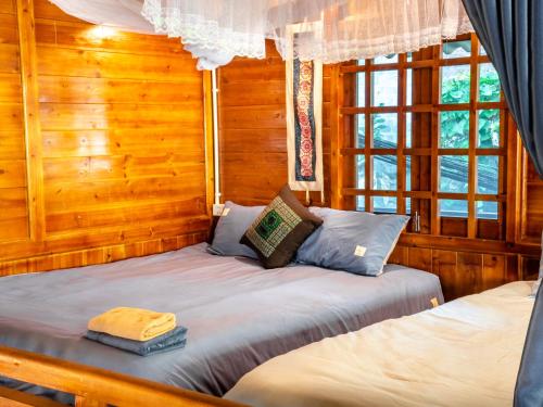 a bedroom with two beds in a log cabin at Wild Apple homestay in Sa Pả
