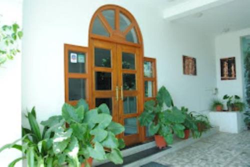 uma porta de madeira com algumas plantas em frente em Hotel Isabel Palace, Khajuraho em Khajurāho