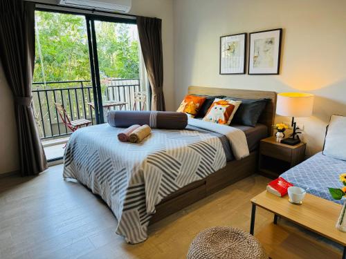 ein Schlafzimmer mit einem Bett und einem Balkon in der Unterkunft HuaHin La Casita condo Quiet, cozy room Netflix#1 in Hua Hin