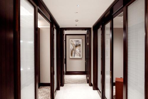 a hallway with glass doors and a painting on the wall at Yancheng Shuicheng Hotel in Yancheng