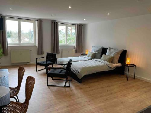 una camera da letto con un grande letto, sedie e finestre di cozy Apartment/WLAN in Neustadt i. Sachsen a Neustadt in Sachsen