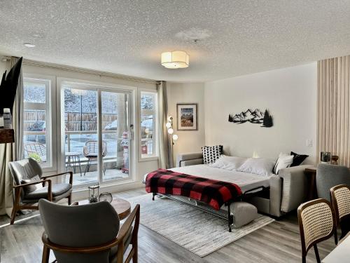 a bedroom with a bed and a living room at NEW! Central Canmore- Whimsical Mountain Retreat in Canmore