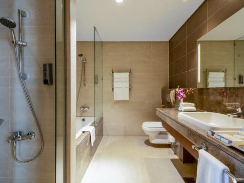 a bathroom with a sink and a toilet and a shower at Flora Al Barsha Hotel At The Mall in Dubai