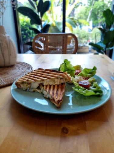 a sandwich and salad on a blue plate on a table at The Peaberry Boutique Hotel in Chiang Mai