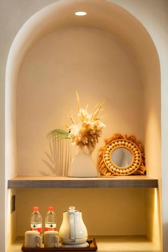 a shelf with a vase of flowers and a mirror at Shenzhen Semporna Beach Sea View B & B - 深圳较场尾仙本那沙滩海景民宿 in Shenzhen