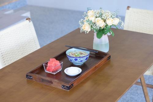 a table with a tray of food and a vase with flowers at Shenzhen Semporna Beach Sea View B & B - 深圳较场尾仙本那沙滩海景民宿 in Shenzhen