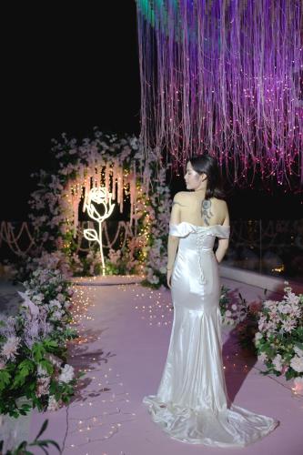 a woman in a white dress standing on a walkway at Shenzhen Semporna Beach Sea View B & B - 深圳较场尾仙本那沙滩海景民宿 in Shenzhen