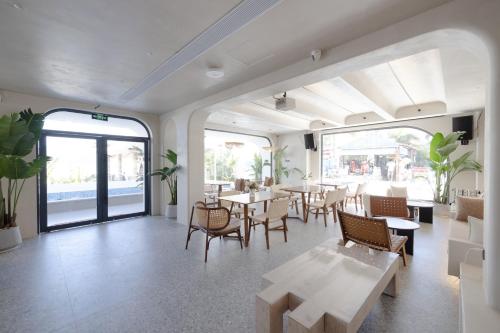a restaurant with tables and chairs in a room at Shenzhen Semporna Beach Sea View B & B - 深圳较场尾仙本那沙滩海景民宿 in Shenzhen