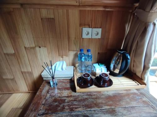- une table avec des bouteilles d'eau et d'autres articles dans l'établissement Aksha Riverside Ubud, à Tampaksiring