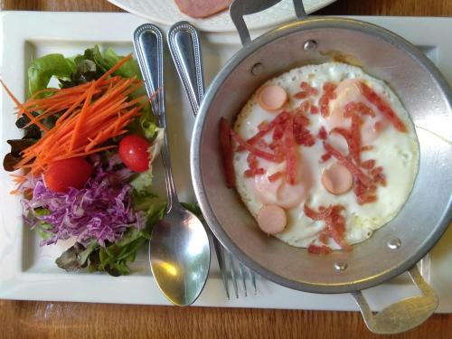 einen Teller mit Essen, eine Schüssel Suppe und Salat in der Unterkunft AuangKham Resort in Lampang