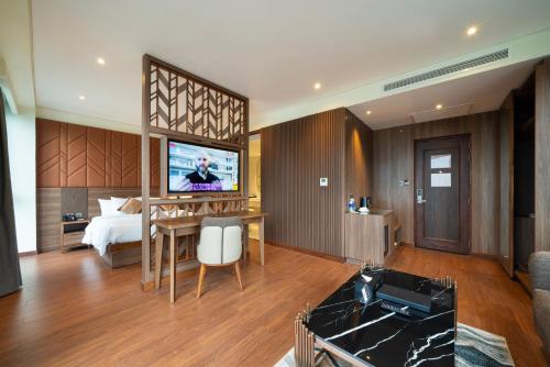 a bedroom with a bed and a television in a room at Northern Charm Hotel in Ho Chi Minh City