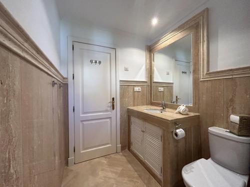 ein Badezimmer mit einem WC, einem Waschbecken und einem Spiegel in der Unterkunft Beach & Golf Apartment in Bahía de Casares in Bahia de Casares