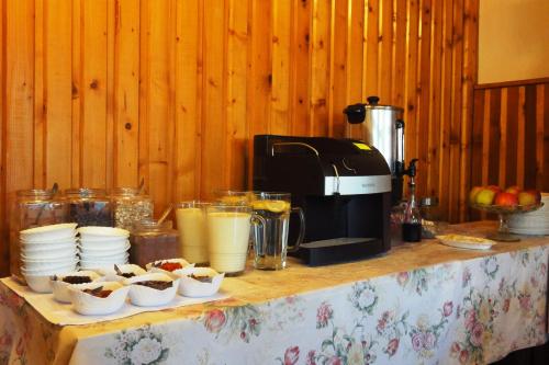 a table with cups of food and a coffee maker at Willa Orla in Zakopane