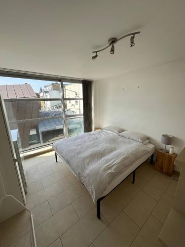 um quarto com uma cama e uma grande janela em Bright And Airy Islington Apartment em Londres