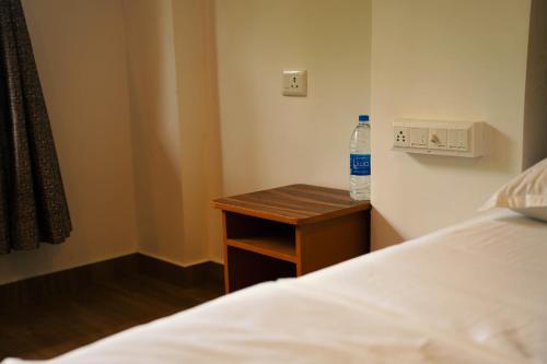 a bottle of water sitting on a table next to a bed at Nature Cascade Resort in Chillithodu