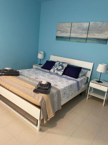 a bedroom with a bed with a blue wall at casa vacanze relax in Vacri