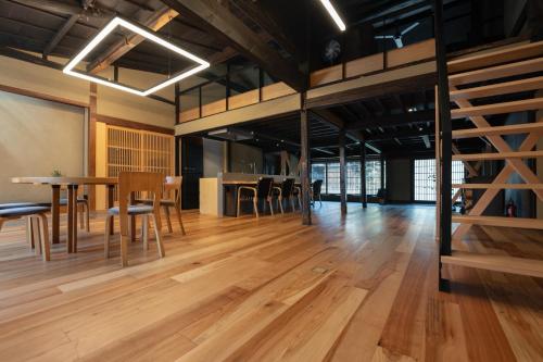 a large room with wooden floors and a table and chairs at 海野宿一棟貸し宿 上州屋 Unnojuku Joshuya in Tomi