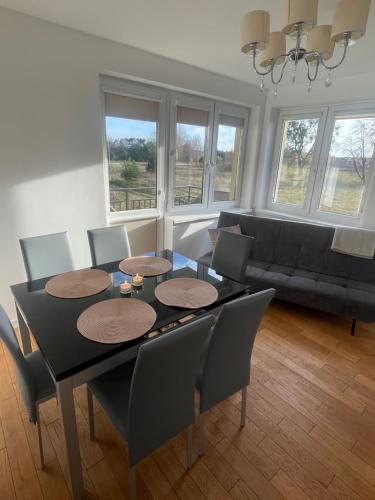 sala de estar con mesa, sillas y sofá en Apartament Szczytno II en Szczytno