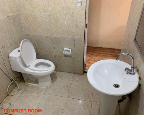 a bathroom with a toilet and a sink at Hana Natsu Resorts Beach & Hotel in Morong