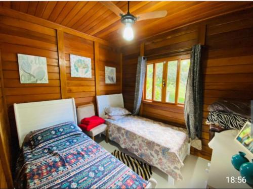 - une chambre avec 2 lits et une fenêtre dans une cabine dans l'établissement Lindo Sítio Em Domingos Martins, à Domingos Martins
