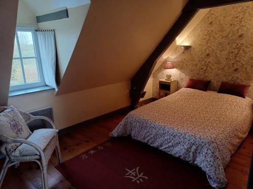 um quarto com uma cama e uma cadeira num sótão em LE GÎTE DU VIGNERON em Sennevières