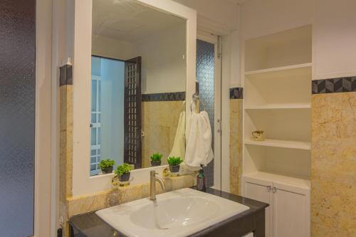 a bathroom with a sink and a mirror at Thabali Oasis:3BHK private pool villa + Sauna in Pattaya South