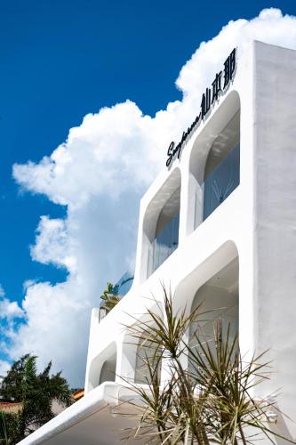 a white building with a sign on top of it at Shenzhen Semporna Beach Sea View B & B - 深圳较场尾仙本那沙滩海景民宿 in Shenzhen