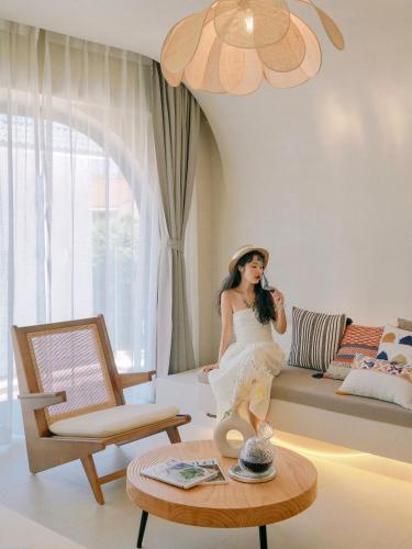 a woman sitting on a couch in a living room at Shenzhen Semporna Beach Sea View B & B - 深圳较场尾仙本那沙滩海景民宿 in Shenzhen